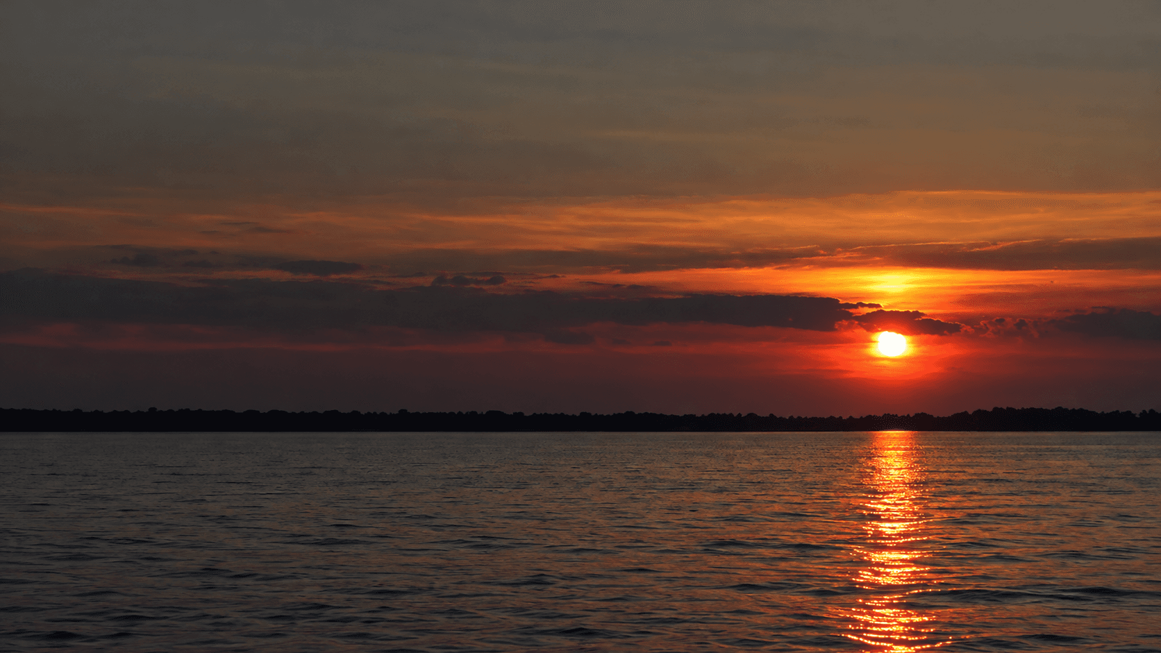 Orange sunset reflecting across calm water